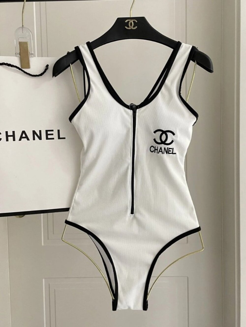 Chanel's white one-piece swimsuit features the iconic double C logo.